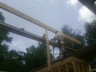 Carpenter setting a ridge beam over a new addition frame — Ice Dam Removal by Roofing Brothers in Eagle Rock