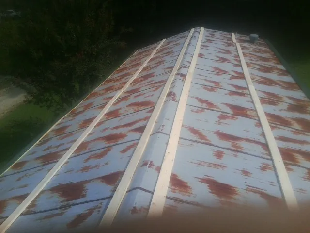 Rusted metal roof panels with new wood purlins before replacement — Storm Damage Roof Repair in Eagle Rock by Roofing Brothers