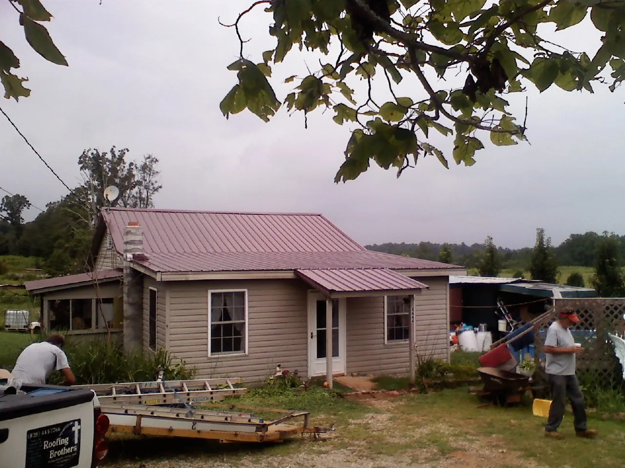 Crew finishing a mauve metal roof on a small farmhouse in Eagle Rock